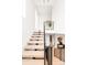 Bright staircase featuring hardwood steps, modern railing, and ample natural light enhancing its elegant design at 1466 S Gaylord St, Denver, CO 80210