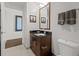 Bathroom with dark vanity, granite countertop, decorative mirror, and neutral tile flooring at 891 14Th St # 3411, Denver, CO 80202