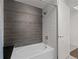 Modern bathroom showcasing a tub with gray tile accent wall and shower fixture at 891 14Th St # 3411, Denver, CO 80202