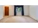 Bright living room featuring carpet, window with dark blue drapes and a view, and entryway to hall at 912 S Kingston St, Aurora, CO 80012