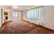 Inviting living room with plush carpet and view to kitchen showcasing window with white curtain at 912 S Kingston St, Aurora, CO 80012