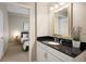 Bathroom featuring black granite countertops, white cabinets, and view through to bedroom at 1975 N Grant St # 617, Denver, CO 80203
