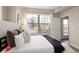 Bright bedroom features a large window with cityscape views and access to a balcony at 1975 N Grant St # 617, Denver, CO 80203