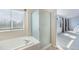 This bathroom features a soaking tub, a glass shower, and a view of the Primary bedroom at 5405 Military Trl, Parker, CO 80134