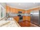 Open concept kitchen with granite counters, stainless steel appliances, and wood cabinets at 5405 Military Trl, Parker, CO 80134