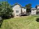 Spacious backyard with a well-kept lawn, mature trees, and a charming wooden deck at 8114 Briar Ridge Dr, Castle Pines, CO 80108