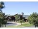 A welcoming clubhouse with a grand entrance, featuring a stone chimney, is framed by lush greenery at 8114 Briar Ridge Dr, Castle Pines, CO 80108