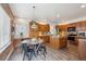 Well-lit kitchen featuring wood cabinets, stainless steel appliances, and an adjacent dining area at 8114 Briar Ridge Dr, Castle Pines, CO 80108