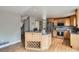 Charming kitchen with wood cabinetry, granite countertops, stainless steel appliances, an island and hardwood floors at 5784 W 81St Cir, Arvada, CO 80003