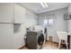 Well-equipped laundry room with front-loading washer, dryer, storage cabinets, and sink at 5784 W 81St Cir, Arvada, CO 80003