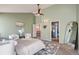 Airy main bedroom featuring neutral decor, plush seating, a ceiling fan, and access to an ensuite bathroom at 5784 W 81St Cir, Arvada, CO 80003