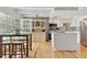 Bright open kitchen with white cabinets, stainless steel appliances, light wood flooring, and a center island at 33 N Corona St # 401, Denver, CO 80218