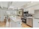 Bright open kitchen with stainless steel appliances, white cabinets, light wood flooring, and a center island at 33 N Corona St # 401, Denver, CO 80218