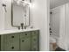 Bathroom with a modern vanity with sage cabinetry, matte black hardware, and a shower-tub combo at 7770 W 38Th Ave # 108, Wheat Ridge, CO 80033