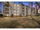 Low angle of complex with white facade and units with balconies overlooking lawn at 7770 W 38Th Ave # 108, Wheat Ridge, CO 80033