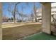 View from an apartment patio towards parking with trees and grass at 7770 W 38Th Ave # 108, Wheat Ridge, CO 80033