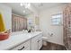 Charming bathroom with a single sink, colorful shower curtain, and a bright window at 10011 Yampa Ct, Commerce City, CO 80022