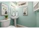 Charming bathroom featuring a pedestal sink and turquoise walls at 7828 Florado St, Denver, CO 80221