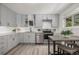 Modern kitchen featuring grey cabinets, stainless steel appliances, and a cozy dining space at 7828 Florado St, Denver, CO 80221