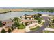 Panoramic aerial view of an estate home featuring a circular driveway, lush landscaping, and lakeside community at 5767 Pelican Shores Dr, Longmont, CO 80504