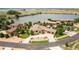 High-angle aerial showcasing a sprawling home with a three-car garage and manicured lawns near a tranquil lake at 5767 Pelican Shores Dr, Longmont, CO 80504