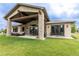 Expansive backyard with a covered patio, stone columns, and a lush green lawn at 5767 Pelican Shores Dr, Longmont, CO 80504