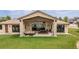 Expansive backyard with a covered patio, outdoor seating, and a lush green lawn at 5767 Pelican Shores Dr, Longmont, CO 80504