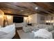 A basement living room with TV, fireplace, comfortable couch, and rustic wood ceiling at 5767 Pelican Shores Dr, Longmont, CO 80504