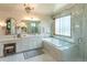 A luxurious bathroom features a double vanity, soaking tub, glass-enclosed shower, and ornate mirrors at 5767 Pelican Shores Dr, Longmont, CO 80504