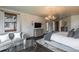 A stylish bedroom features a cozy seating area, a large window, and a modern chandelier at 5767 Pelican Shores Dr, Longmont, CO 80504