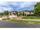 Beautiful stone home featuring a private driveway and three-car garage, all on a sprawling lawn at 5767 Pelican Shores Dr, Longmont, CO 80504