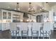 Kitchen with white cabinetry, stainless steel appliances, breakfast bar, and modern lighting at 5767 Pelican Shores Dr, Longmont, CO 80504