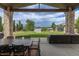 Covered patio boasting stone columns, outdoor seating, dining, and tranquil lake views at 5767 Pelican Shores Dr, Longmont, CO 80504