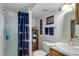 Well-lit bathroom showcases a shower with Denver Broncos themed shower curtain and sports memorabilia at 7840 S Windermere Cir, Littleton, CO 80120