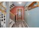 Inviting entryway features a staircase, wooden door with glass, and coat rack for convenience at 7840 S Windermere Cir, Littleton, CO 80120