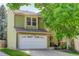 Charming home exterior with a two-car garage, and lush landscaping in a green neighborhood at 7840 S Windermere Cir, Littleton, CO 80120