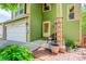Inviting covered porch with cozy seating, brick pathway, and well manicured landscaping at 7840 S Windermere Cir, Littleton, CO 80120