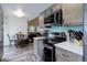 Modern kitchen featuring stainless steel appliances, gray cabinets, and sleek countertops, seamlessly flowing into the dining area at 7840 S Windermere Cir, Littleton, CO 80120