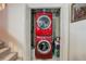 Laundry area features a stacked red washer and dryer with convenient storage space at 7840 S Windermere Cir, Littleton, CO 80120