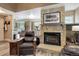Inviting living room featuring a stone fireplace adjacent to the kitchen at 7840 S Windermere Cir, Littleton, CO 80120