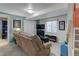 Inviting living room with a large sofa, television, and adjacent bathroom with a shower at 7840 S Windermere Cir, Littleton, CO 80120