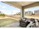 Covered patio showcasing outdoor seating, a fire pit, and a view of the fenced yard at 11052 Sedalia St, Commerce City, CO 80022