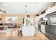 Open-concept kitchen featuring stainless steel appliances, granite countertops, and a center island with seating at 11052 Sedalia St, Commerce City, CO 80022