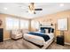 Bright main bedroom features a ceiling fan, cozy sitting area, and comfortable bed at 11052 Sedalia St, Commerce City, CO 80022