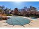Community pool with safety cover surrounded by mature trees and well-maintained landscaping at 13792 E Lehigh Ave # E, Aurora, CO 80014
