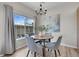 Cozy dining room featuring a round table, four chairs, modern chandelier, and a large bright window at 1050 Opal St # 102, Broomfield, CO 80020
