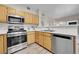 Functional kitchen featuring stainless steel appliances, wooden cabinets, and white countertops at 1050 Opal St # 102, Broomfield, CO 80020