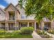 Charming townhome with a brick facade, covered porch, iron railing, and beautiful landscaping at 600 E Dry Creek Pl, Littleton, CO 80122