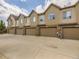 Row of townhome garages with brick facades, overhead doors, and individual entryways at 600 E Dry Creek Pl, Littleton, CO 80122