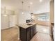 Stylish kitchen island with granite countertops and pendant lighting open to living room at 600 E Dry Creek Pl, Littleton, CO 80122
